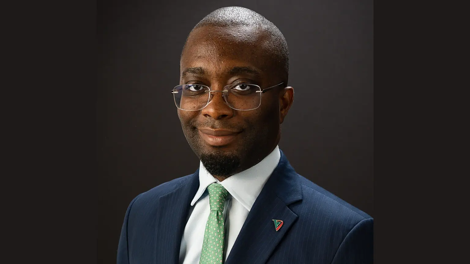 Portrait of Abbey Bank Managing Director and CEO Mobolaji Adewumi in a suit and glasses