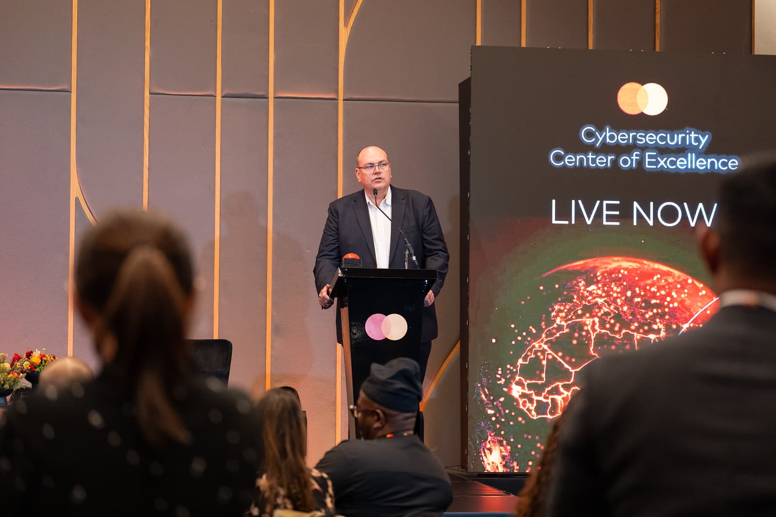 A speaker addressing an audience at a cybersecurity center launch event